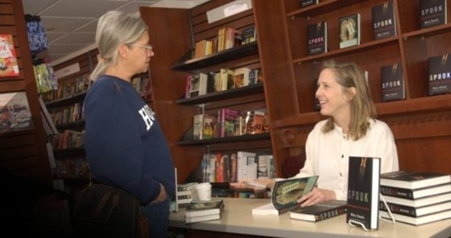 Author signing book in the campus bookstore.